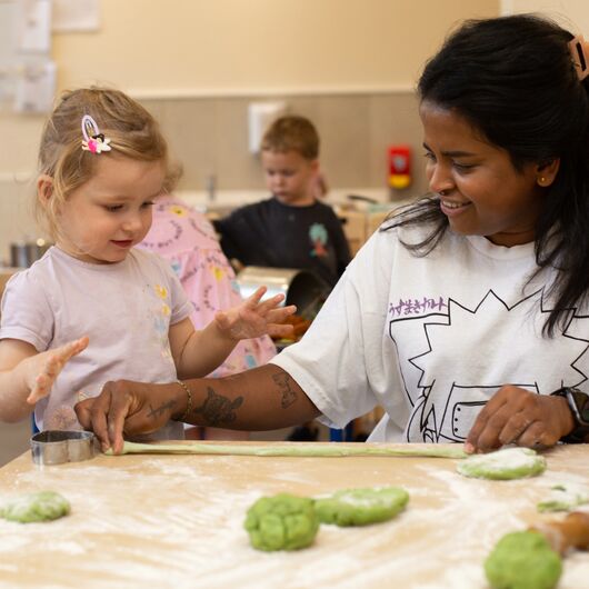 A teacher and child doing playdough activity.
