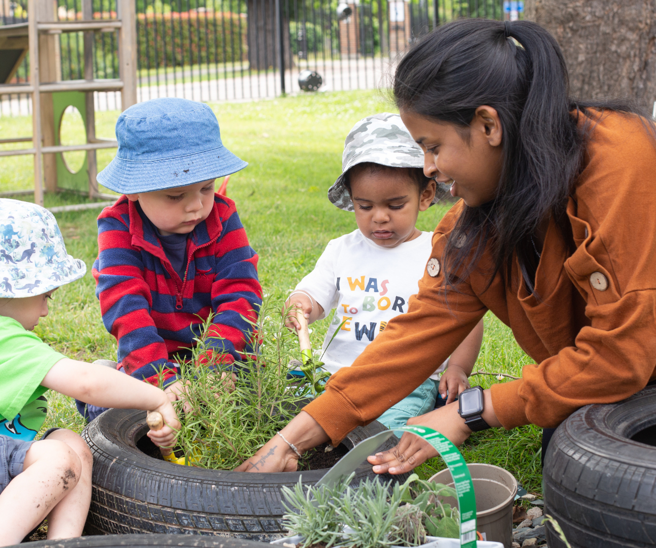 A teacher and children at Bushy Tails gardening