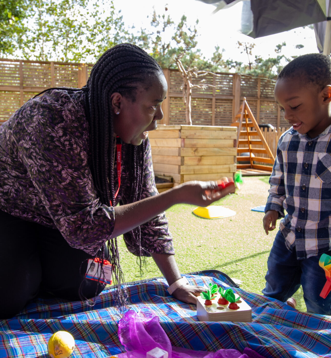 Child and teacher playing on mat