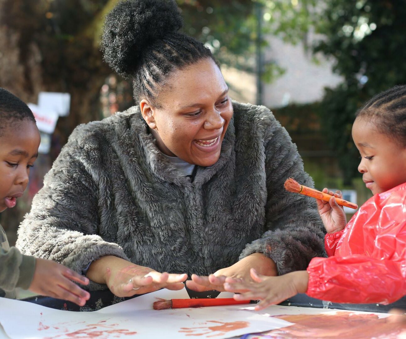 Teacher and children enjoying painting outdoors