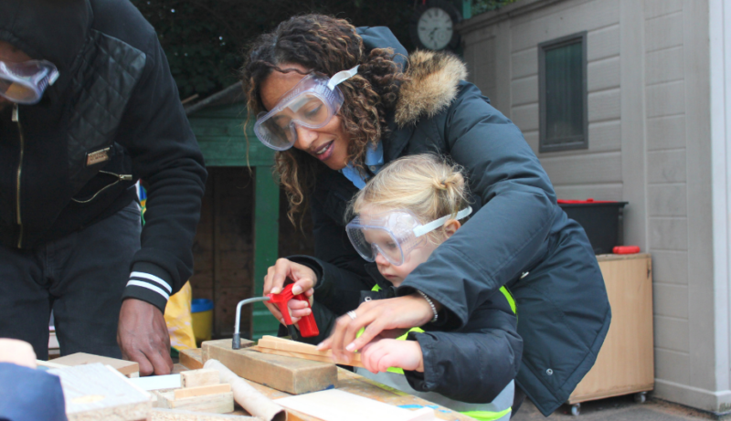 Staff member helping a child with woodwork