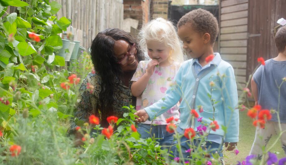 Staff member showing children flowers in Bessborough garden
