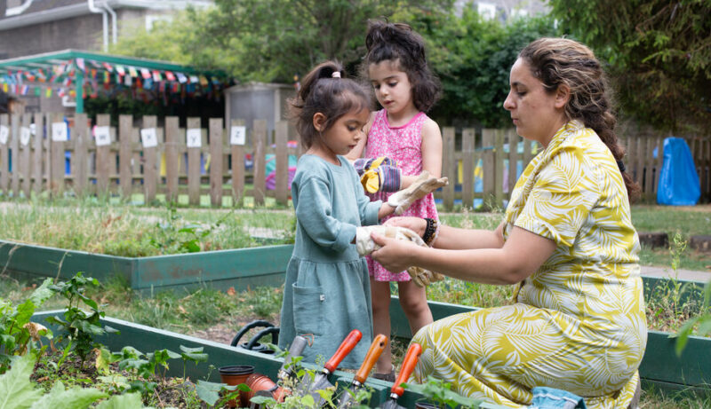 Children putting on their gardening gloves at Children's Garden Nursery