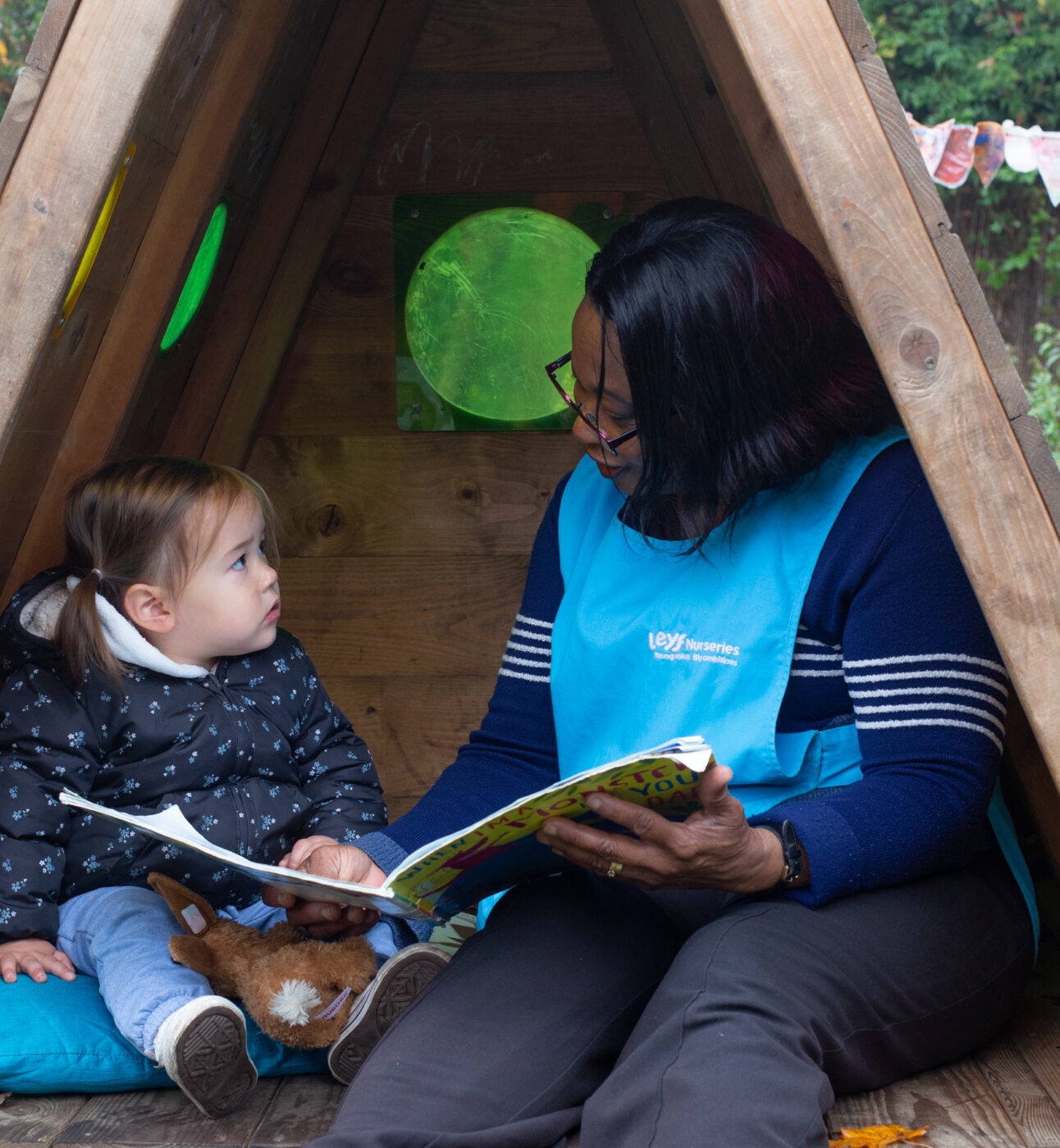 Teacher reading to a child in the garden
