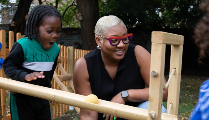 Excited child rolling a ball down a marble run