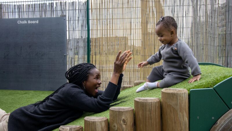 Baby going down the obstacle course with encouragement from teacher practioner