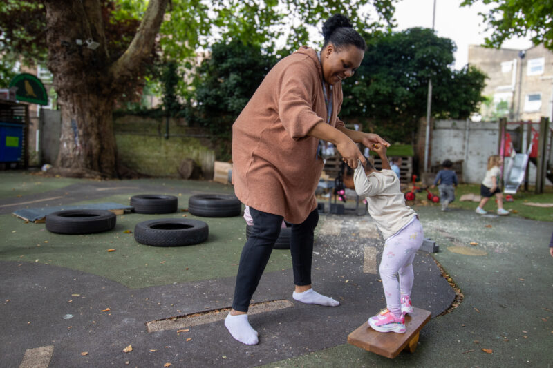 Old Kent Road Nursery Teacher Practitioner Educator helping child to balance.